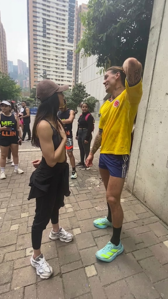 Tatiana conversando en la calle con un corredor, rodeados de otros corredores.