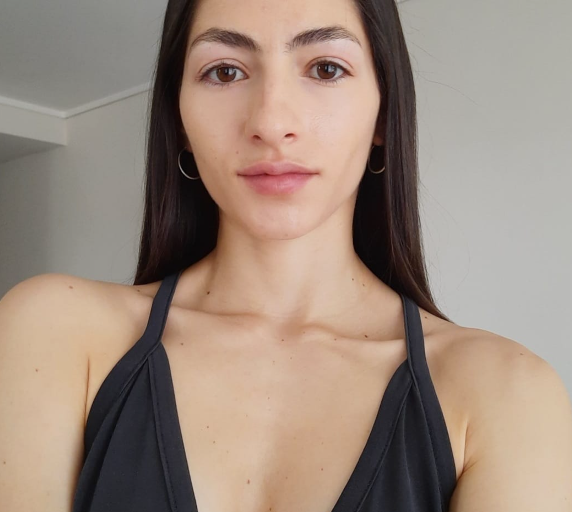 Caso de piel, después: retrato con top negro sobre pared clara.